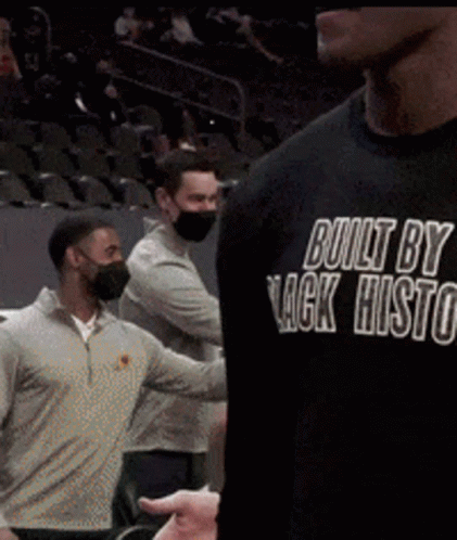 A Man Wearing A Black Shirt That Says Built By Lack Histo GIF