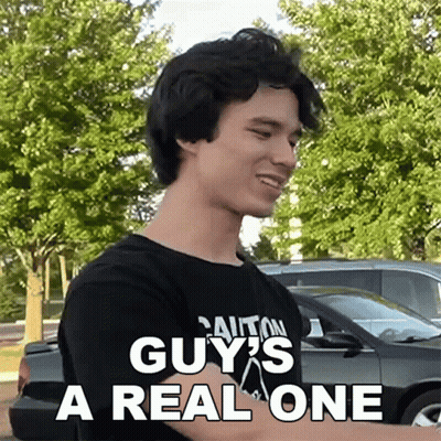 A Man Wearing A Black Shirt That Says Caution Guy 'S A Real One On It GIF