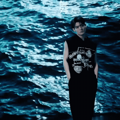 A Man Wearing A Black Shirt That Says Chanel GIF