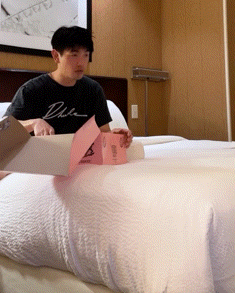 A Man Wearing A Black Shirt That Says Duke Is Sitting On A Bed GIF