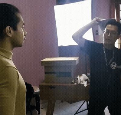 A Man Wearing A Black Shirt That Says ' I Am A Photographer ' On It Stands Next To Another Man GIF