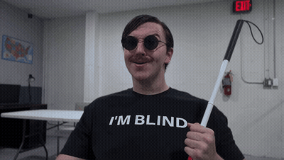 A Man Wearing A Black Shirt That Says I 'M Blind GIF