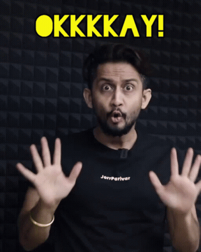 A Man Wearing A Black Shirt That Says Jerryparivar Shows His Hands In Front Of A Sign That Says Okkkay GIF