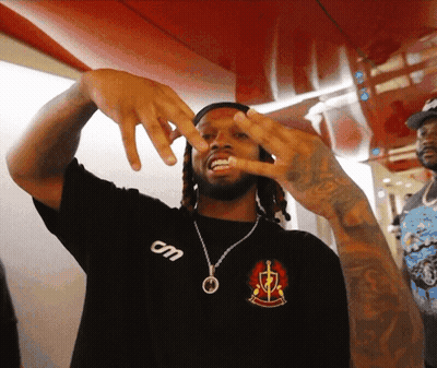 A Man Wearing A Black Shirt That Says Om On The Front GIF