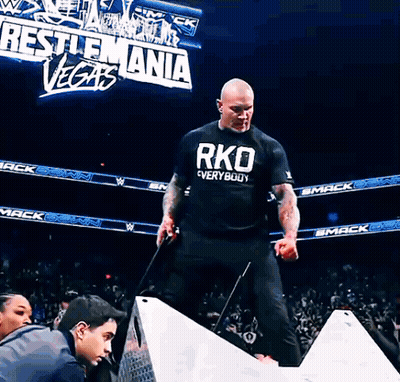 A Man Wearing A Black Shirt That Says Rko Everywhere GIF