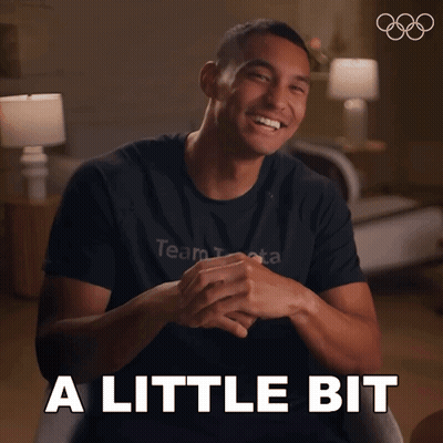 A Man Wearing A Black Shirt That Says Team Beta Smiles And Says A Little Bit GIF