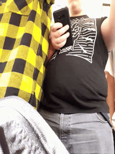 A Man Wearing A Black Shirt That Says ' Thrasher ' On It Holds A Cell Phone GIF