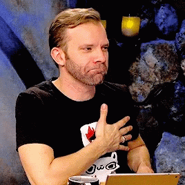 A Man Wearing A Black Shirt With A Cat On It Is Sitting In Front Of A Tablet GIF