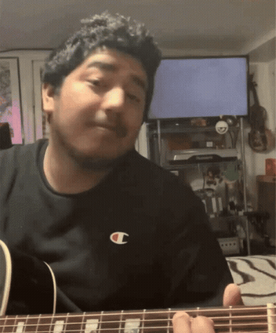 A Man Wearing A Black Shirt With A Champion Logo On It Playing A Guitar GIF