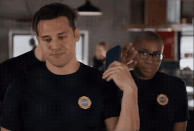 A Man Wearing A Black Shirt With A Fire Department Patch On It GIF