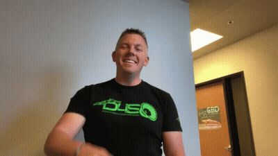 A Man Wearing A Black Shirt With A Green Logo That Says Dsq GIF