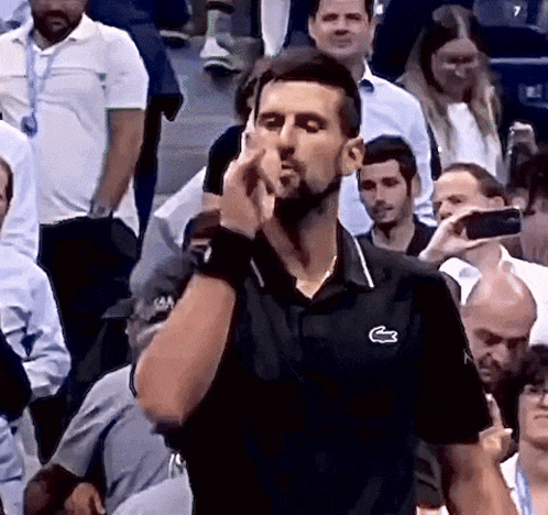 A Man Wearing A Black Shirt With A Lacoste Logo On The Front GIF