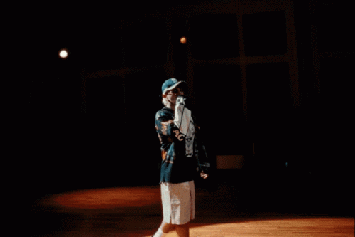 A Man Wearing A Black Shirt With A Skull On It Is Standing In Front Of A Light GIF