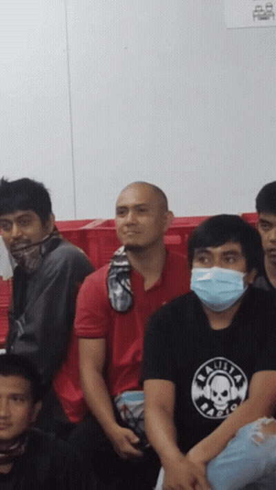A Man Wearing A Black Shirt With A Skull On It Sits In A Crowd GIF
