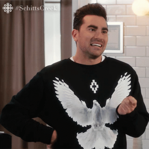 A Man Wearing A Black Shirt With A White Bird On It GIF