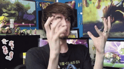 A Man Wearing A Black Shirt With Chinese Writing On It Makes A Funny Face GIF