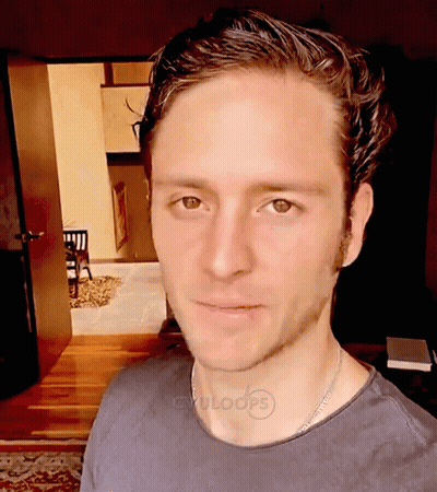 A Man Wearing A Black Shirt With Cvuloops Written On The Collar GIF