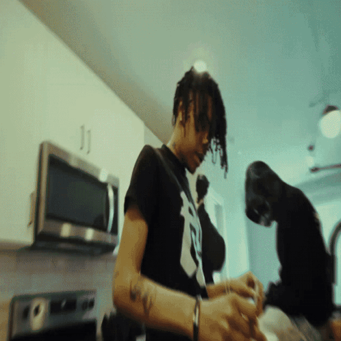 A Man Wearing A Black Shirt With The Letter B On It GIF