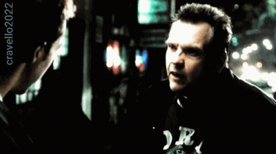 A Man Wearing A Black Shirt With The Letter R On It Talks To Another Man GIF