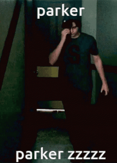 A Man Wearing A Black Shirt With The Letter S On It Wipes His Nose GIF