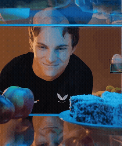 A Man Wearing A Black Shirt With The Letter V On It Looks At A Cake GIF