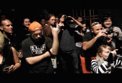 A Man Wearing A Black Shirt With The Number 2 On It Stands In A Crowd GIF