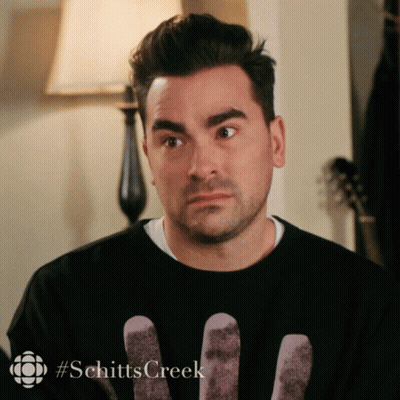 A Man Wearing A Black Shirt With The Word Schitts Creek On The Bottom GIF