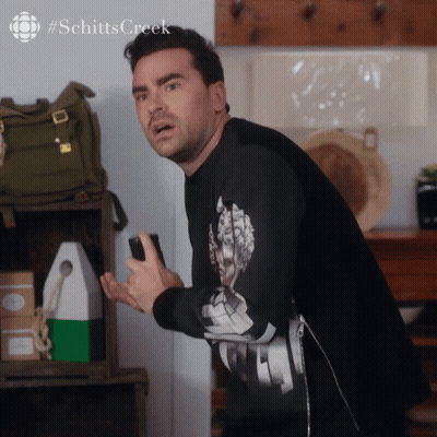 A Man Wearing A Black Shirt With The Word Schitts Creek On The Bottom GIF