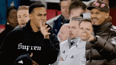 A Man Wearing A Black Supreme Sweatshirt Stands In A Crowd Of People GIF