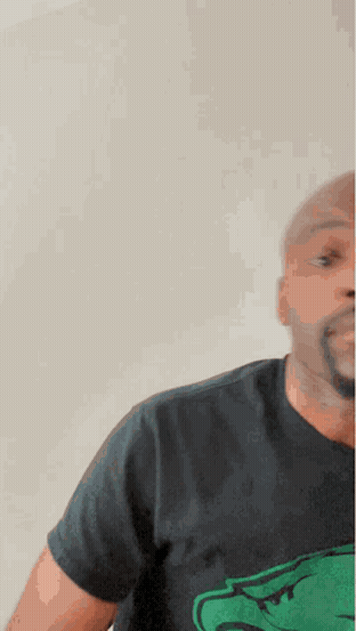 A Man Wearing A Black T-Shirt With A Green Crocodile On It GIF