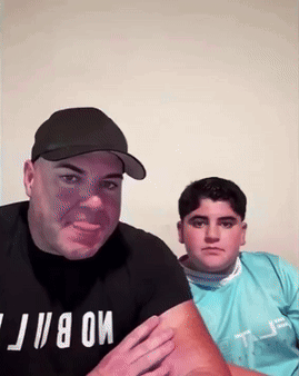 A Man Wearing A Black T-Shirt With The Word Mobi On It Stands Next To Another Man GIF
