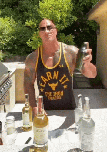 A Man Wearing A Black Tank Top That Says Earn It The Iron Paradise GIF