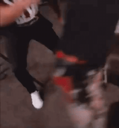 A Man Wearing A Black Tank Top With The Word Swat On It Is Being Held By Another Man . GIF