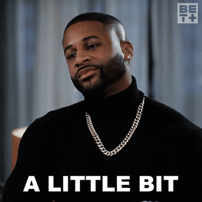 A Man Wearing A Black Turtleneck And A Gold Chain Says A Little Bit GIF