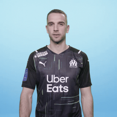 A Man Wearing A Black Uber Eats Shirt Stands In Front Of A Blue Background GIF