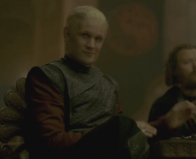 A Man Wearing A Black Vest And Red Shirt Is Clapping His Hands GIF