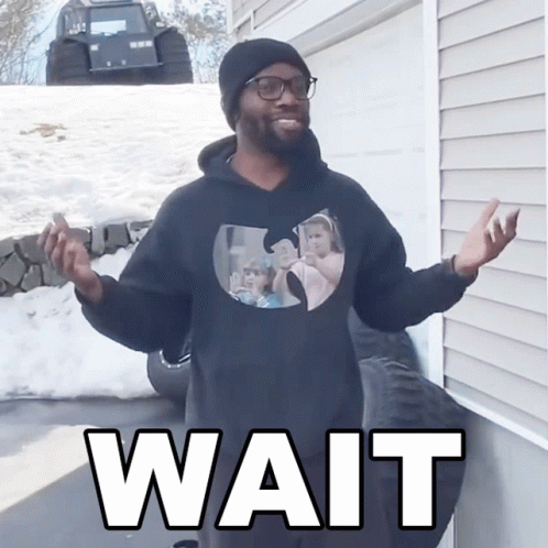 A Man Wearing A Black Wu Tang Sweatshirt Says Wait GIF