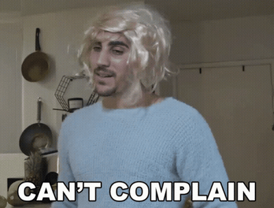 A Man Wearing A Blonde Wig And A Blue Sweater Says " Can 'T Complain " GIF