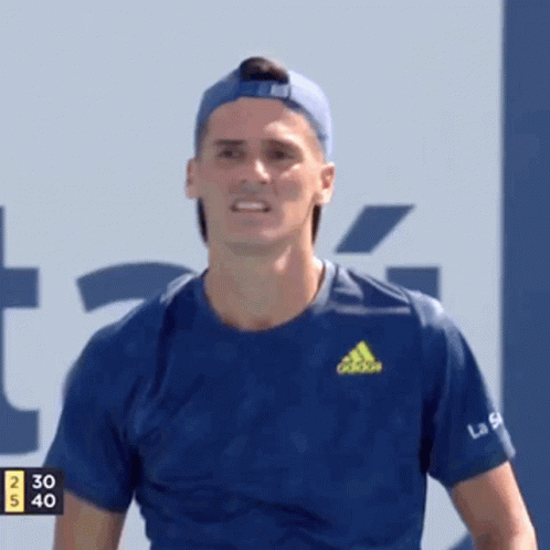 A Man Wearing A Blue Adidas Shirt And A Blue Hat Is Smiling . GIF
