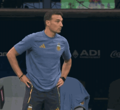 A Man Wearing A Blue Adidas Shirt Stands In Front Of A Coca Cola Sign GIF
