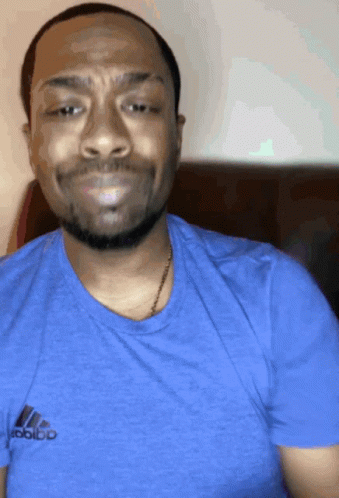 A Man Wearing A Blue Adidas T-Shirt Is Smiling GIF