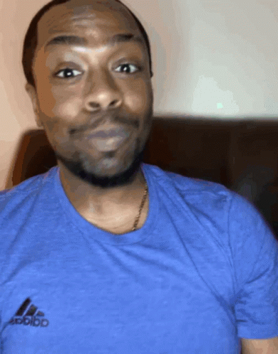 A Man Wearing A Blue Adidas T-Shirt Looks At The Camera GIF