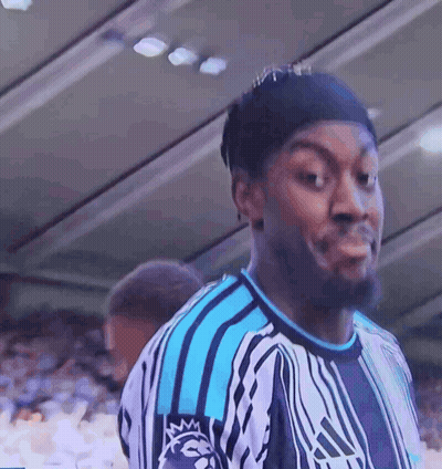 A Man Wearing A Blue And White Adidas Shirt Looks At The Camera GIF