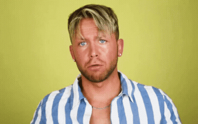 A Man Wearing A Blue And White Striped Shirt Looks At The Camera GIF