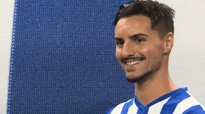 A Man Wearing A Blue And White Striped Shirt Smiles For The Camera GIF