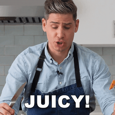 A Man Wearing A Blue Apron Says Juicy In A Kitchen GIF