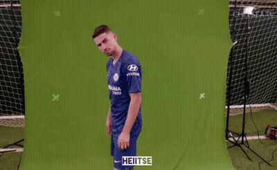 A Man Wearing A Blue Chelsea Jersey Stands In Front Of A Green Screen GIF