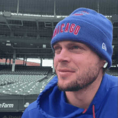 A Man Wearing A Blue Chicago Beanie Stands In Front Of An Empty Stadium GIF