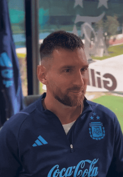 A Man Wearing A Blue Coca Cola Shirt Looks At The Camera GIF