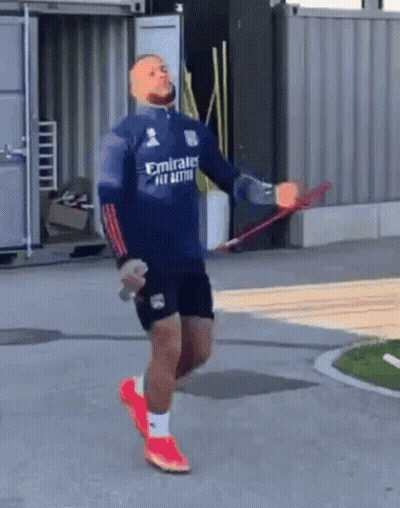 A Man Wearing A Blue Emirates Shirt Is Jumping A Rope GIF